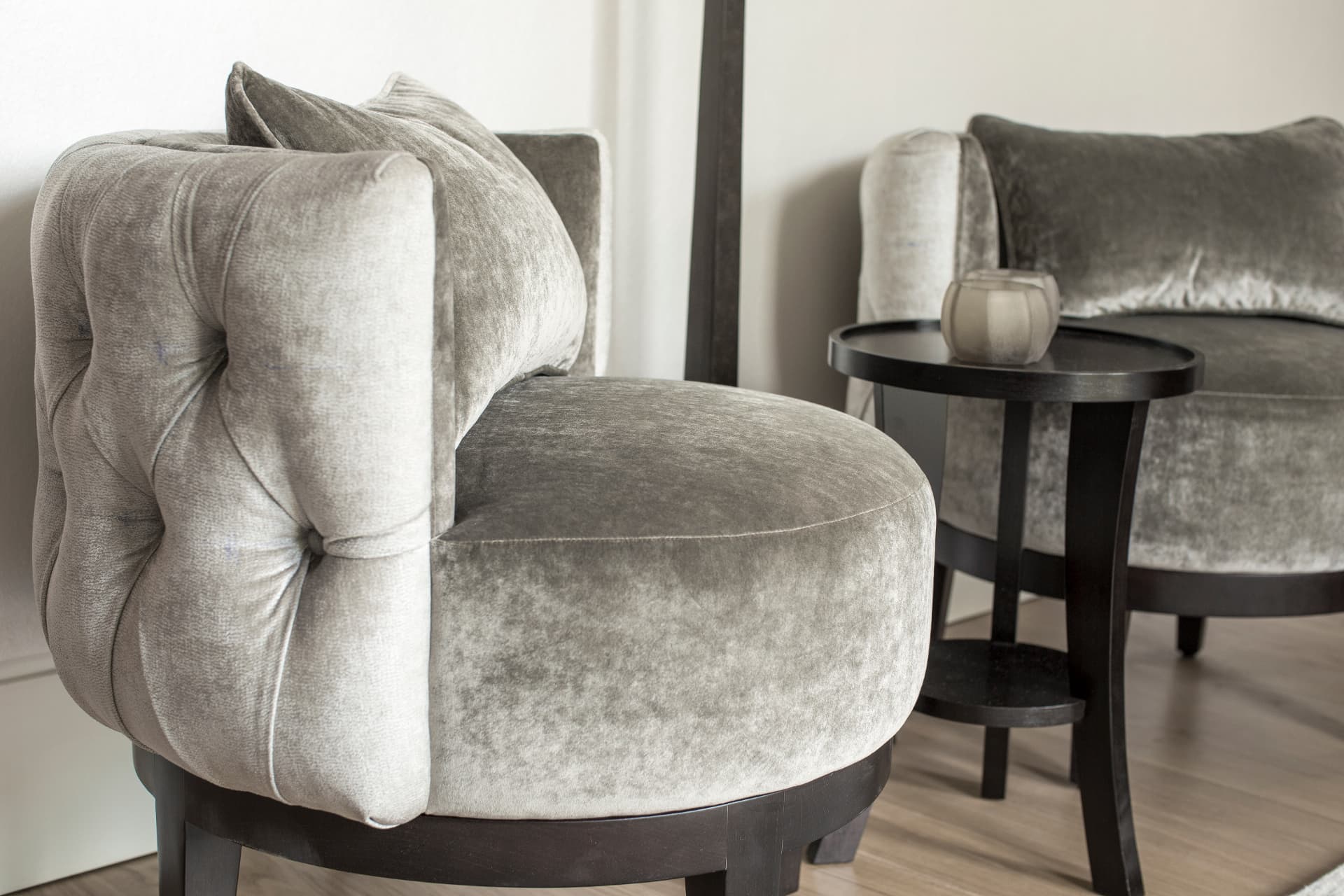Pair of grey upholstered chairs with a dark round side table at Holland Park.