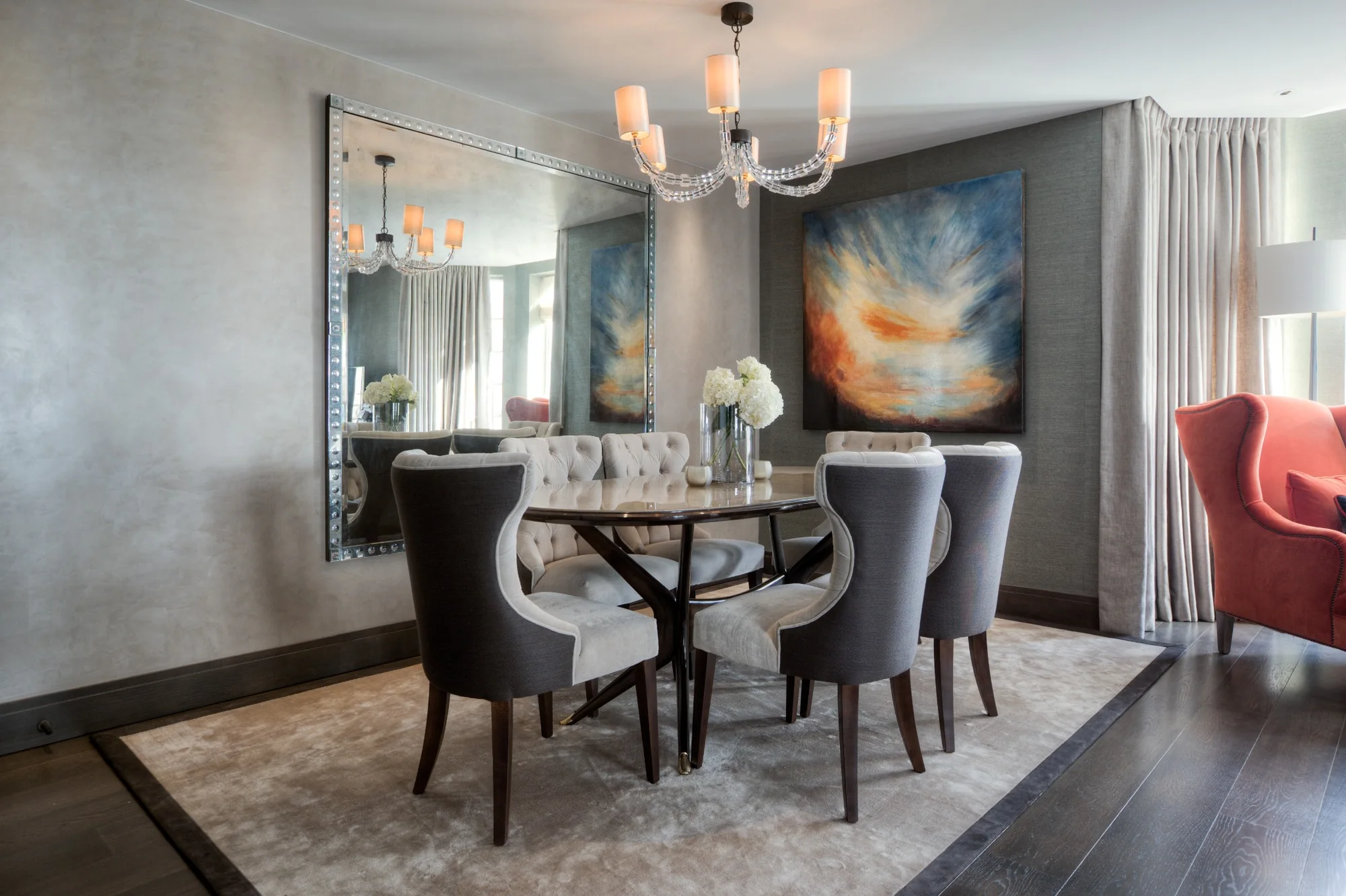 Dining room with polished plaster walls, sculptural chairs and a painting at Kensington Green.