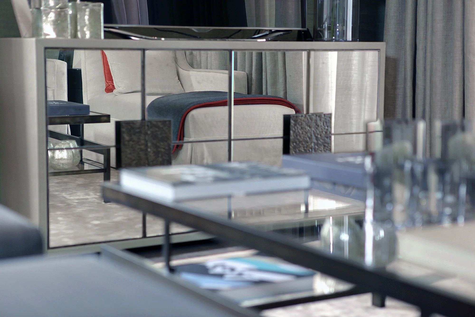Detail of the glass coffee table and upholstered stools in the reception room.
