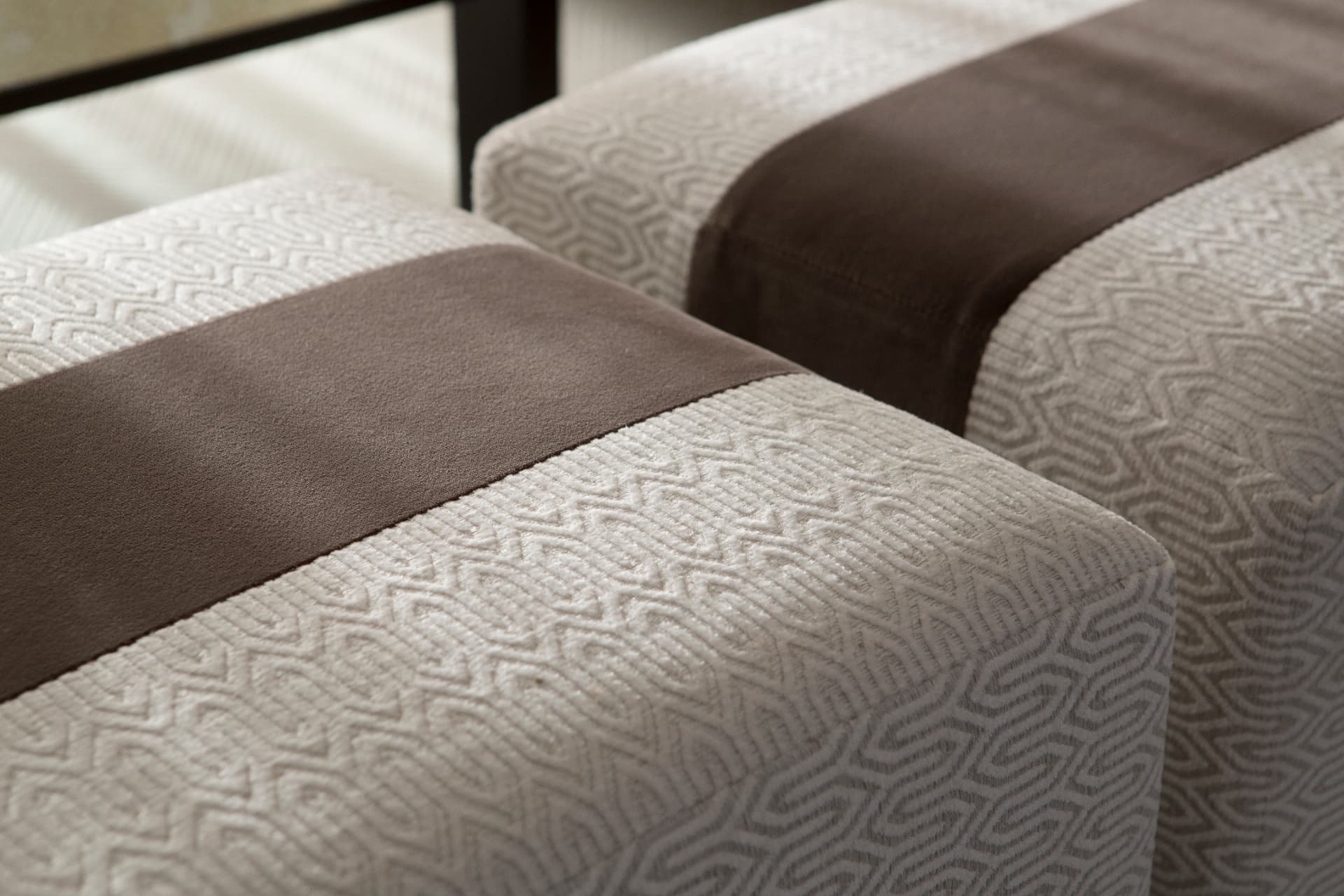 Close-up of patterned upholstered ottomans with a contrasting band.