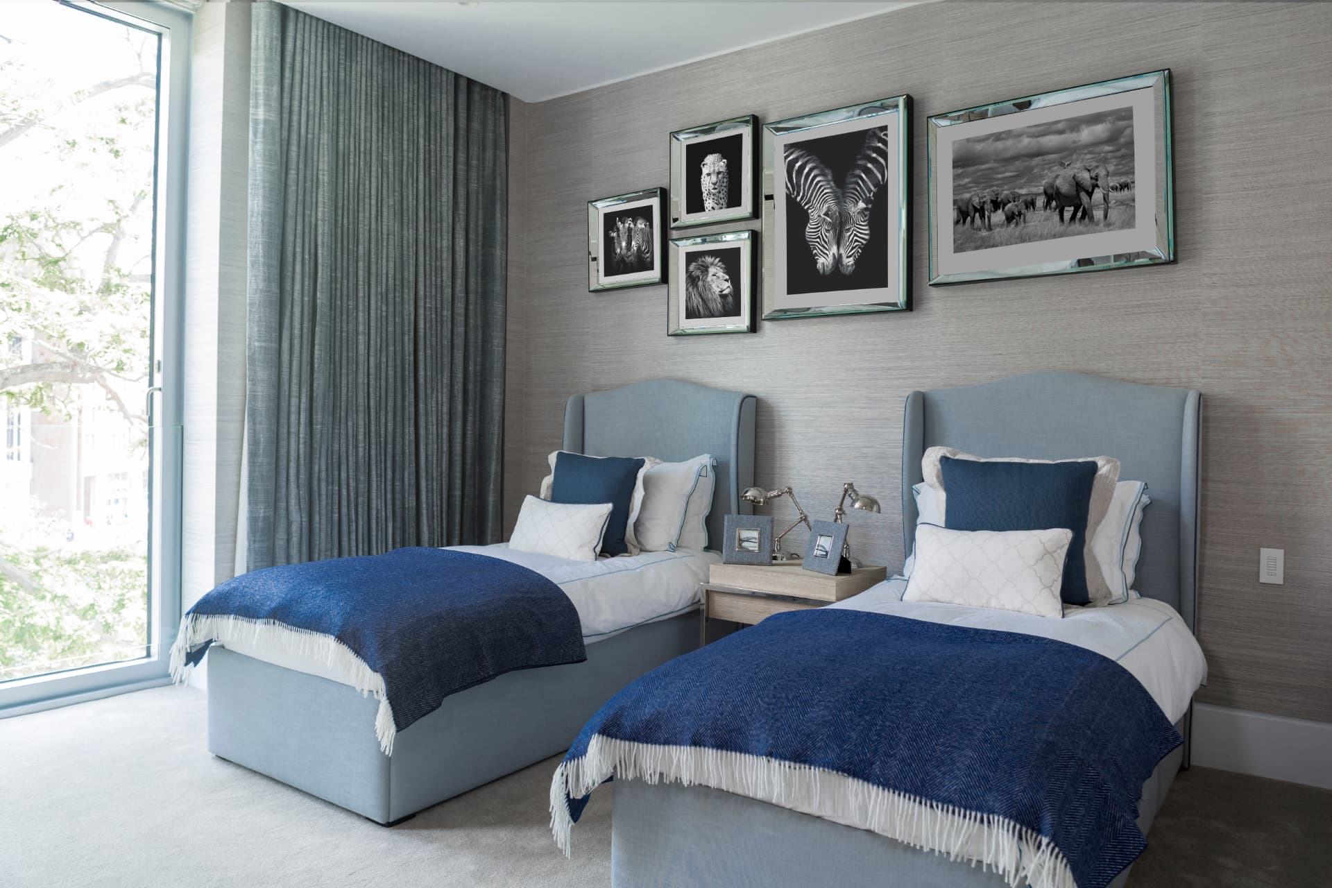 Twin bedroom with pale blue upholstered headboards and deep blue throws.