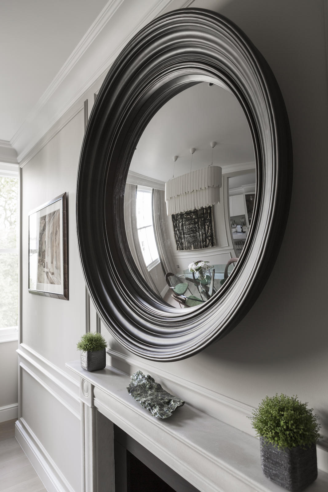 Stanhope Gardens round-mirror detail above a white mantelpiece.