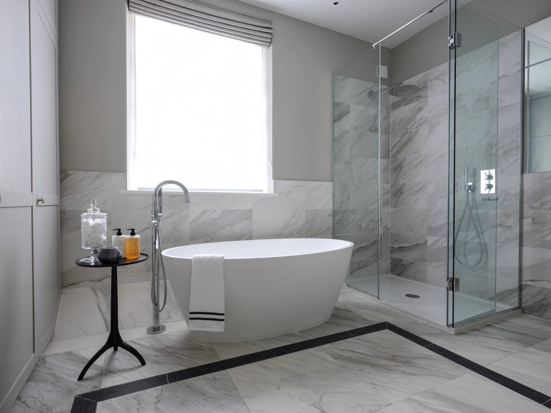 Belgrave Mews South marble bathroom with a freestanding bath and glass shower.