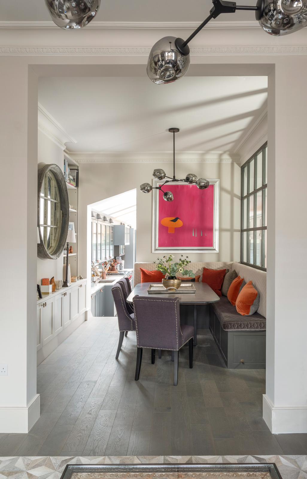 Colourful dining-room interior with a pink artwork and purple chairs.