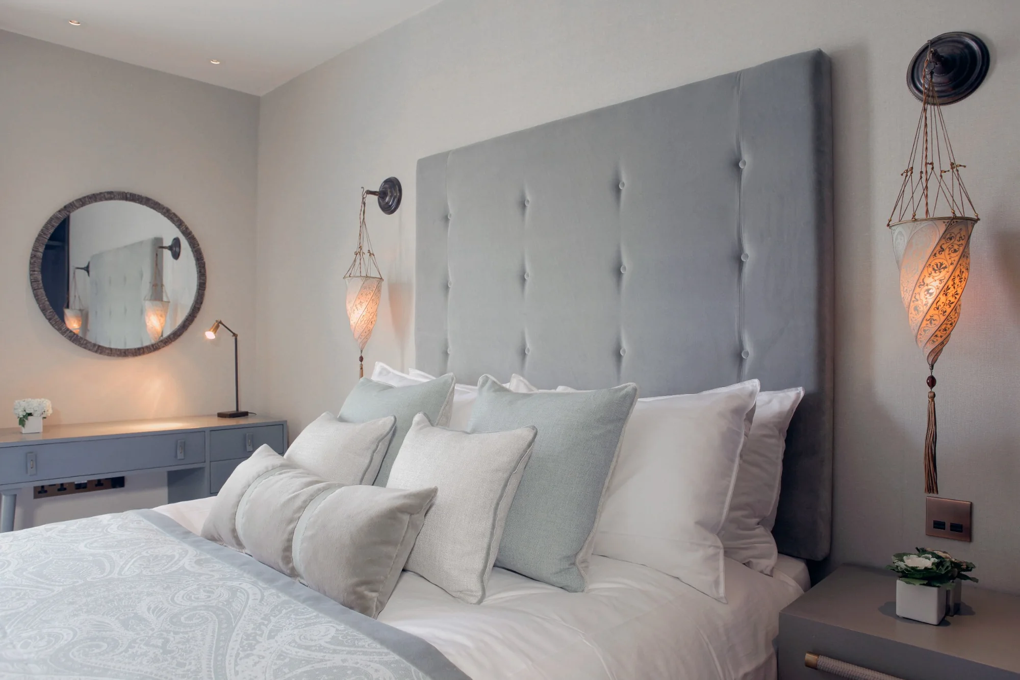 Kensington Green bedroom with a padded headboard and pendant lights.